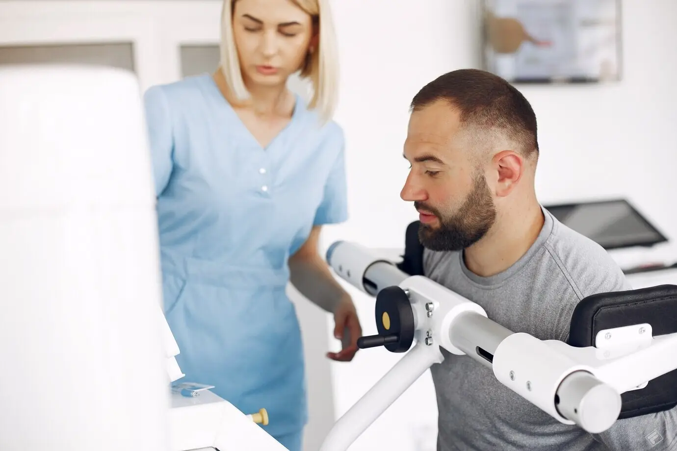 Пациент выполняет упражнения на спортивном оборудовании вместе с терапевтом.